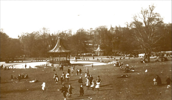 Vintage photo of Clifton Park with people playing in the park and bandstand.