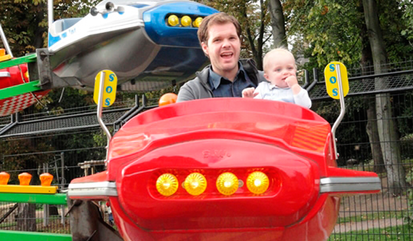 Man and child on a space ride attraction.