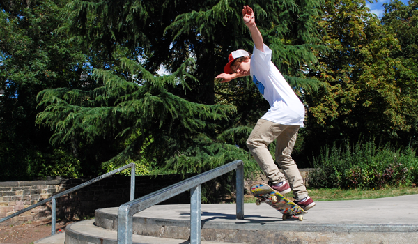 Skateboarder doing a rail slide at the skatepark